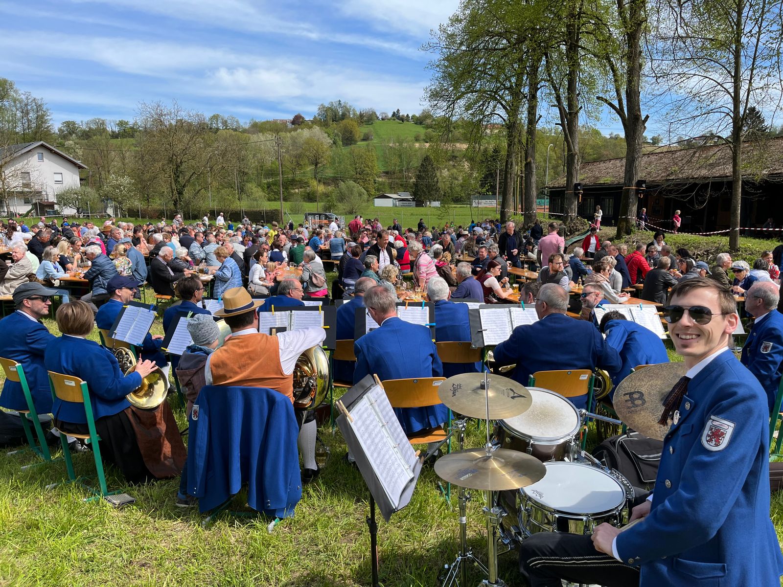 Gemeinschaftsveranstaltung im Freien mit der Live-Band Stadtkapelle Leonding und sitzendem Publikum, das die Aufführung genießt.